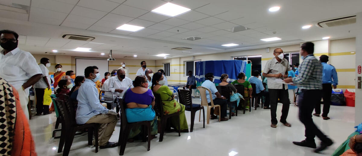 An image of numerous people sitting in a hospital lobby in Kurnool